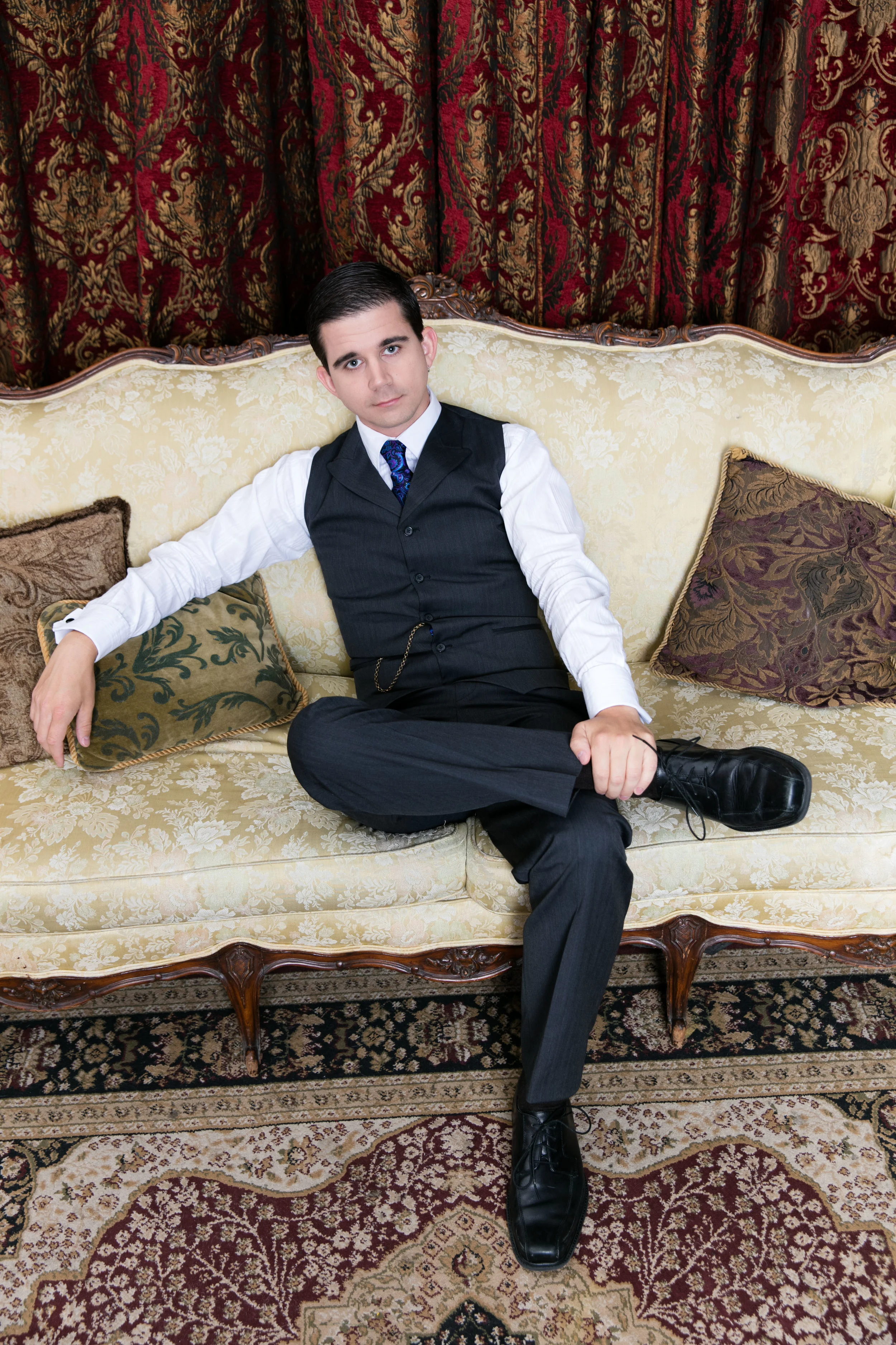 Lee Huff in a three-piece suit on a vintage couch