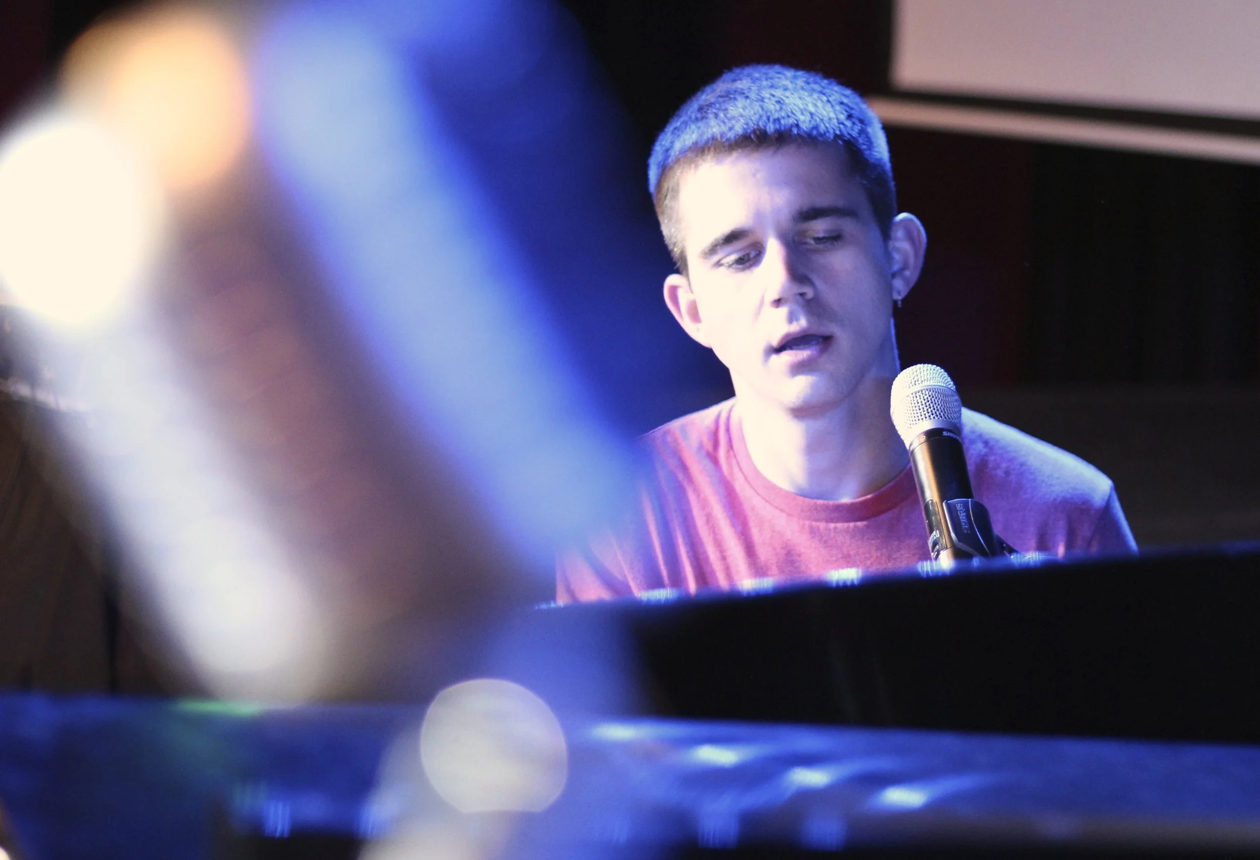 Lee Huff singing and playing piano on stage